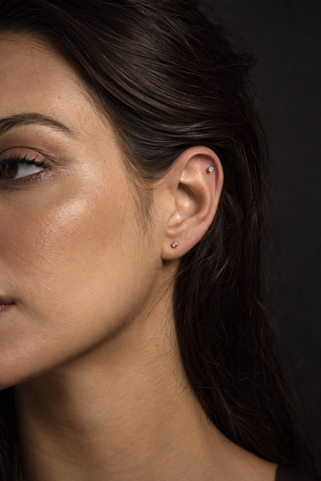 Detalhe de composição de piercings na orelha