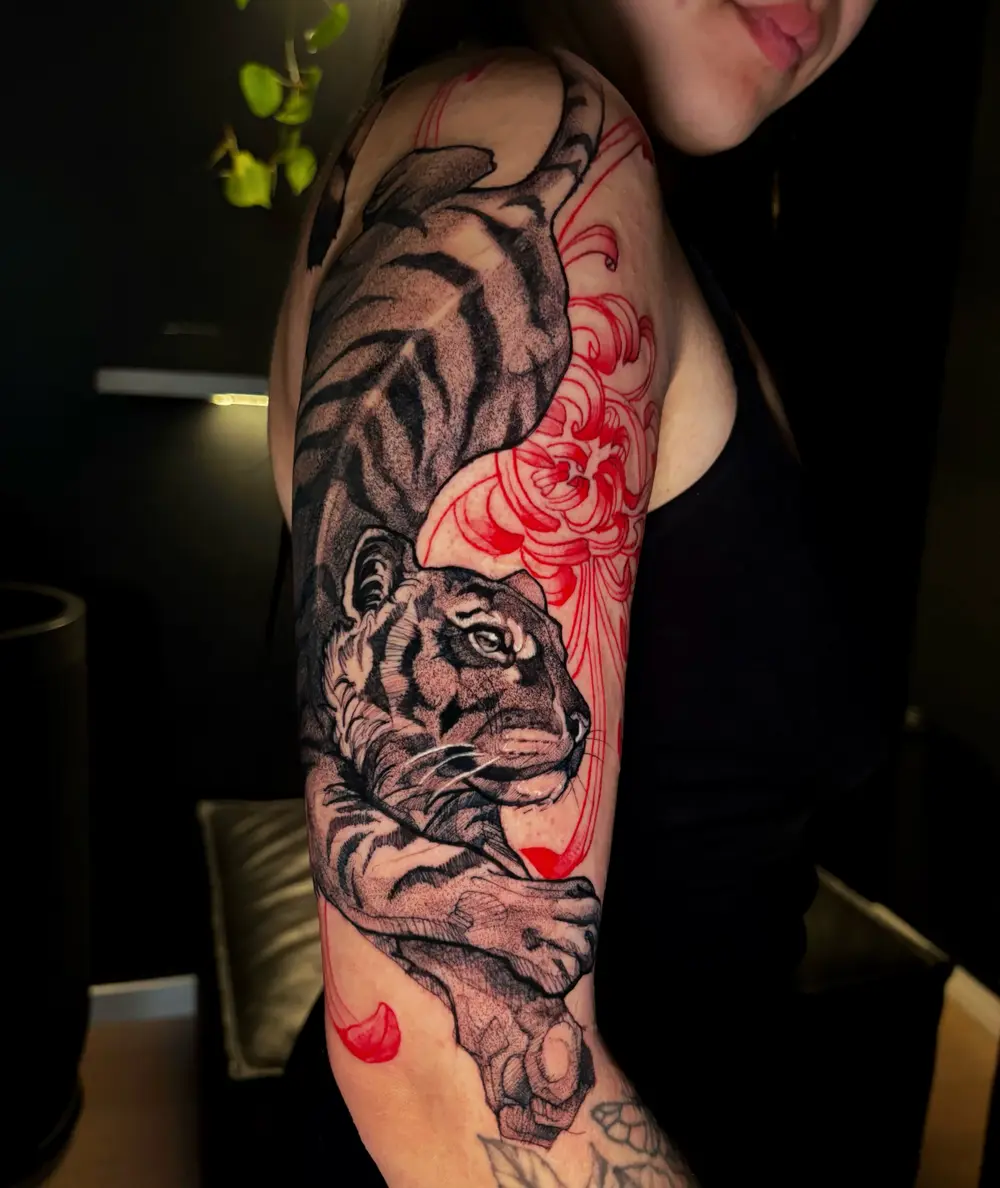 Tigre em realismo com crisântemo vermelho no braço